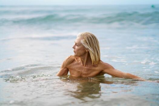 mature-woman-in-good-shape-bathing-in-the-sea-photo